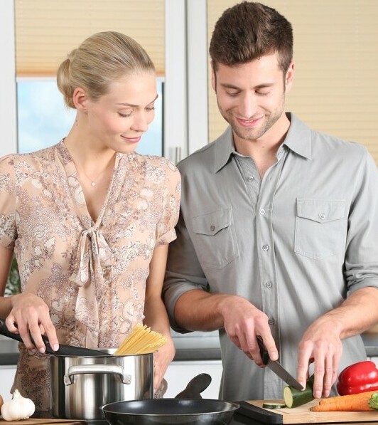 A smiling couple cook healthy meals together after having found recipes and meal plans through ENERGIA VITA.