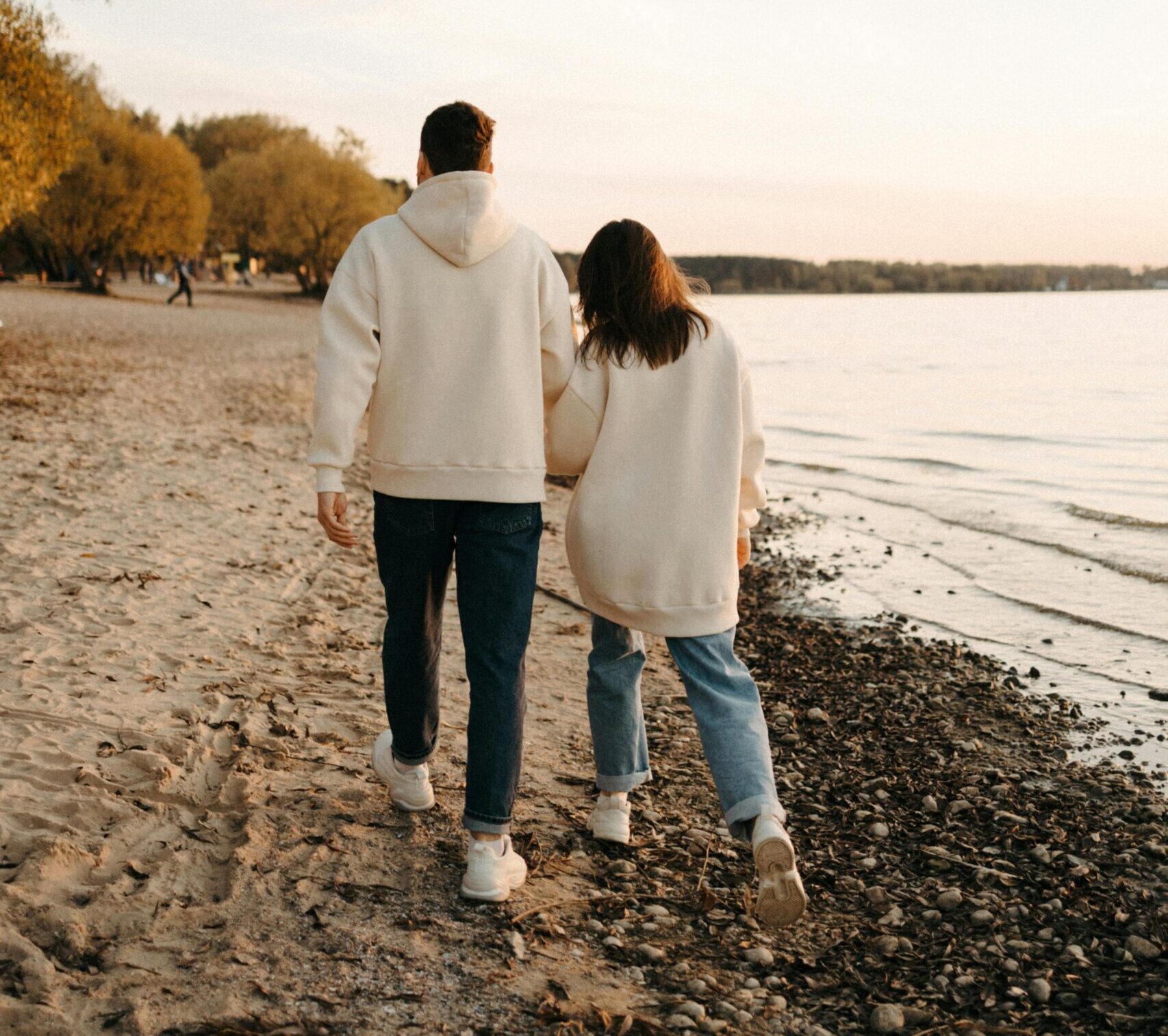 A couple walking on the beach, representing a peaceful and stress-relieving activity that promotes neuroplasticity and mental well-being.