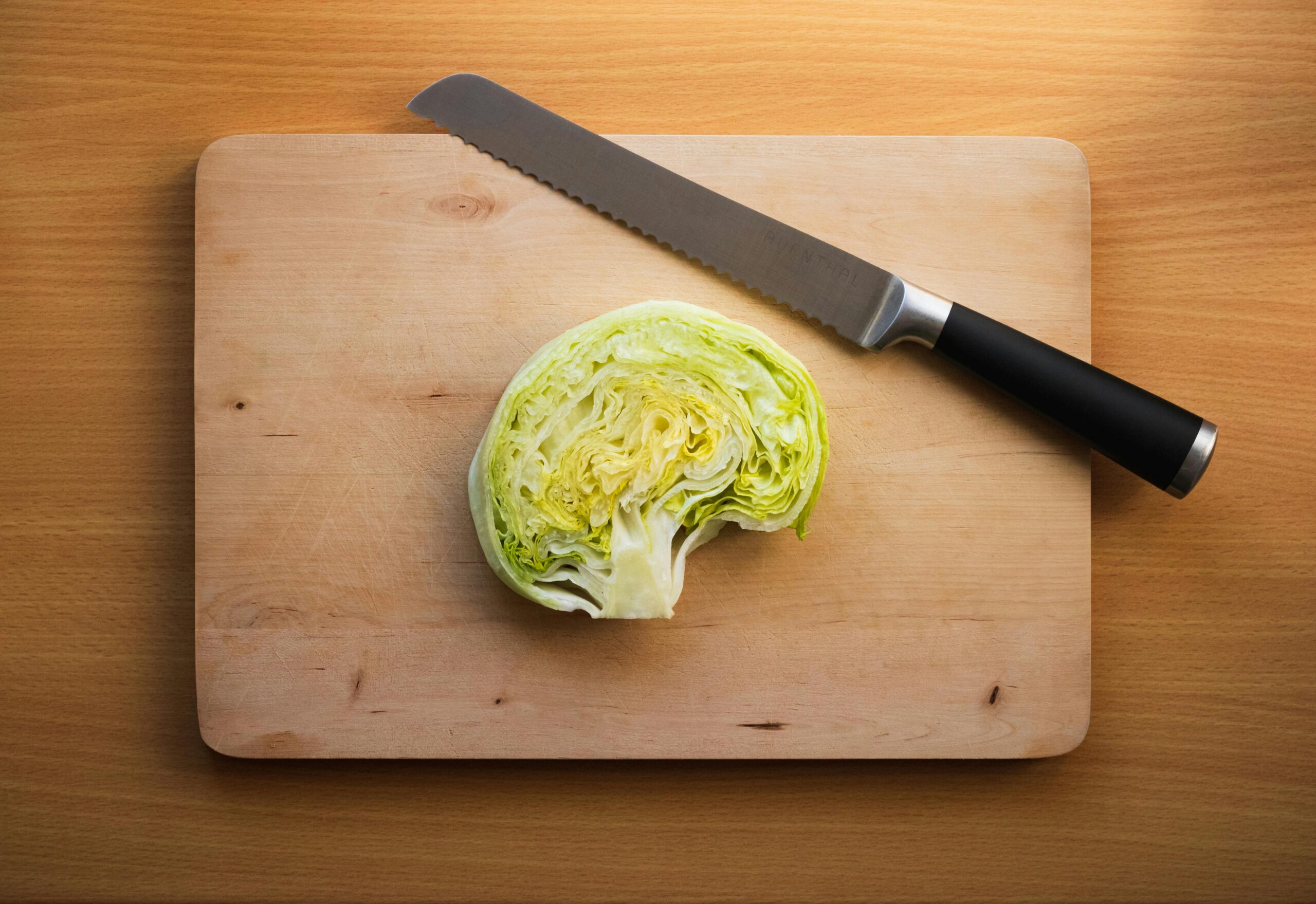 Dissected head of lettuce resembling the human brain on a wooden cutting board.